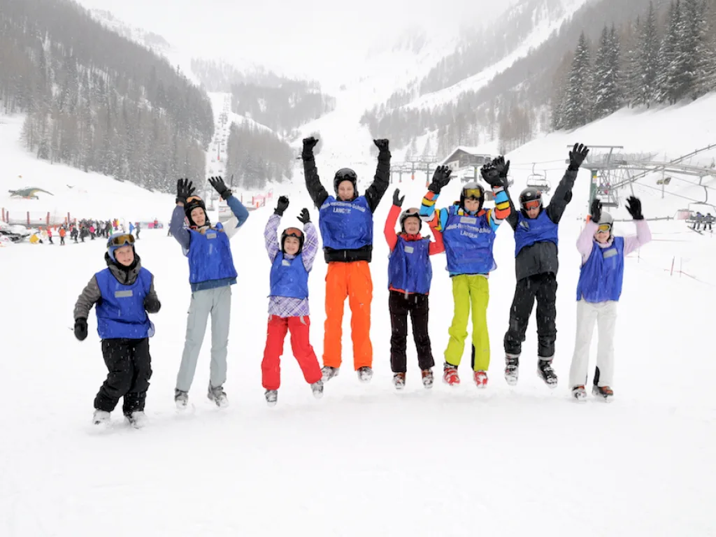 Gruppe springt vor der Bergkulisse in die Luft.